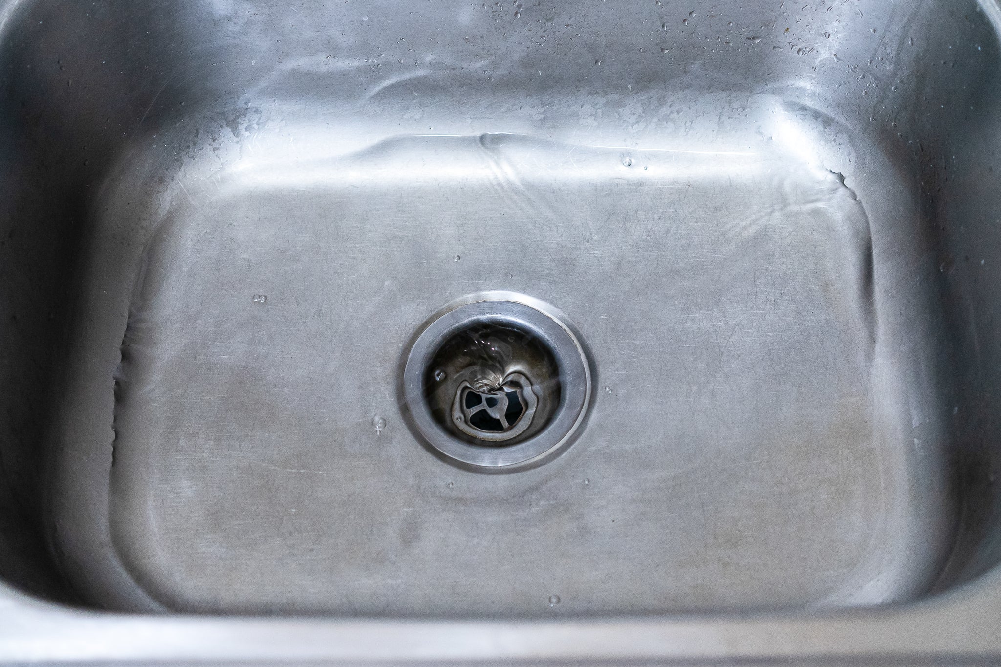 clogged kitchen sink with sitting water